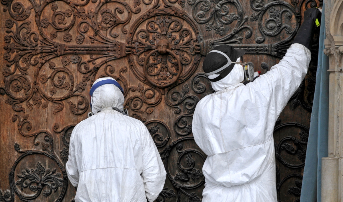 Restauration de Notre-Dame de Paris - compagnons protégés par des combinaisons. Photo Philophoto/AdobeStock