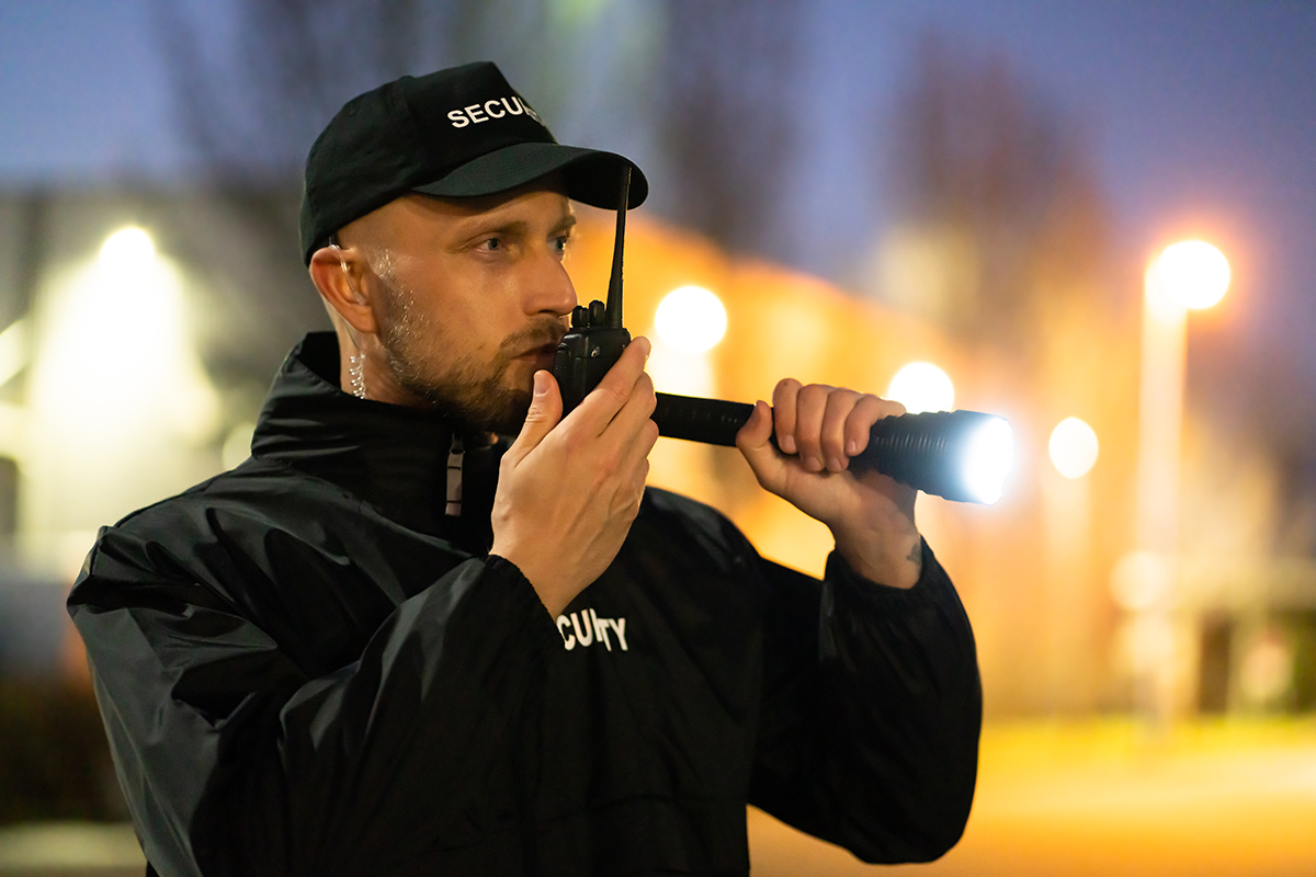 Security Guard Officer Using Walkie-Talkie Radio - Crédit: Andrey Popov/AdobeStock