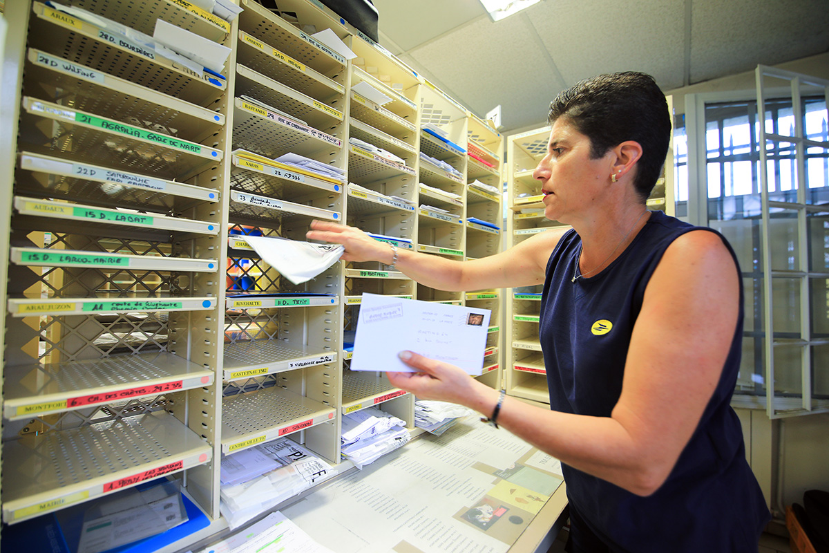 Factrice en travaux intérieur sur casier de tri - Crédit: La Poste