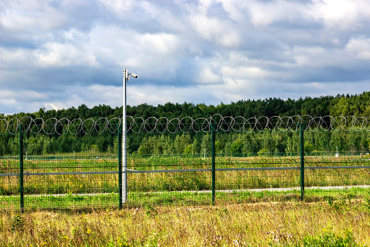Fence, barbed wire and video camera - Crédit: Sergofan2015/AdobeStock