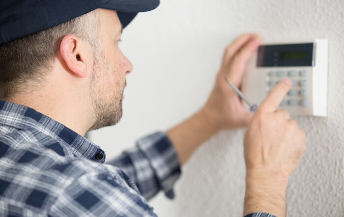 male contractor programming electronic keypad on the wall - Crédit: Auremar/AdobeStock