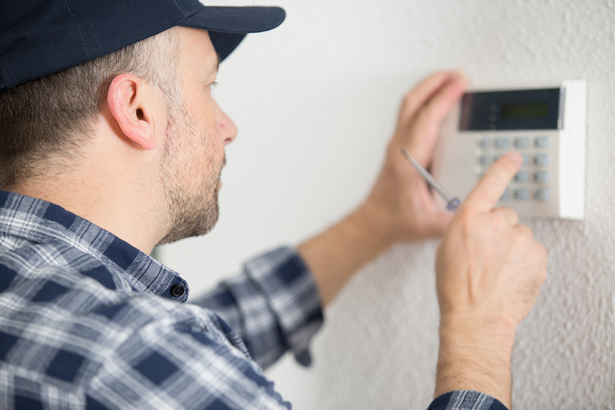 male contractor programming electronic keypad on the wall - Crédit: Auremar/AdobeStock