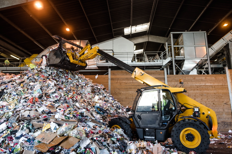 Vue à l'intérieur d'une installation de gestion des déchets, avec une montagne de déchets.